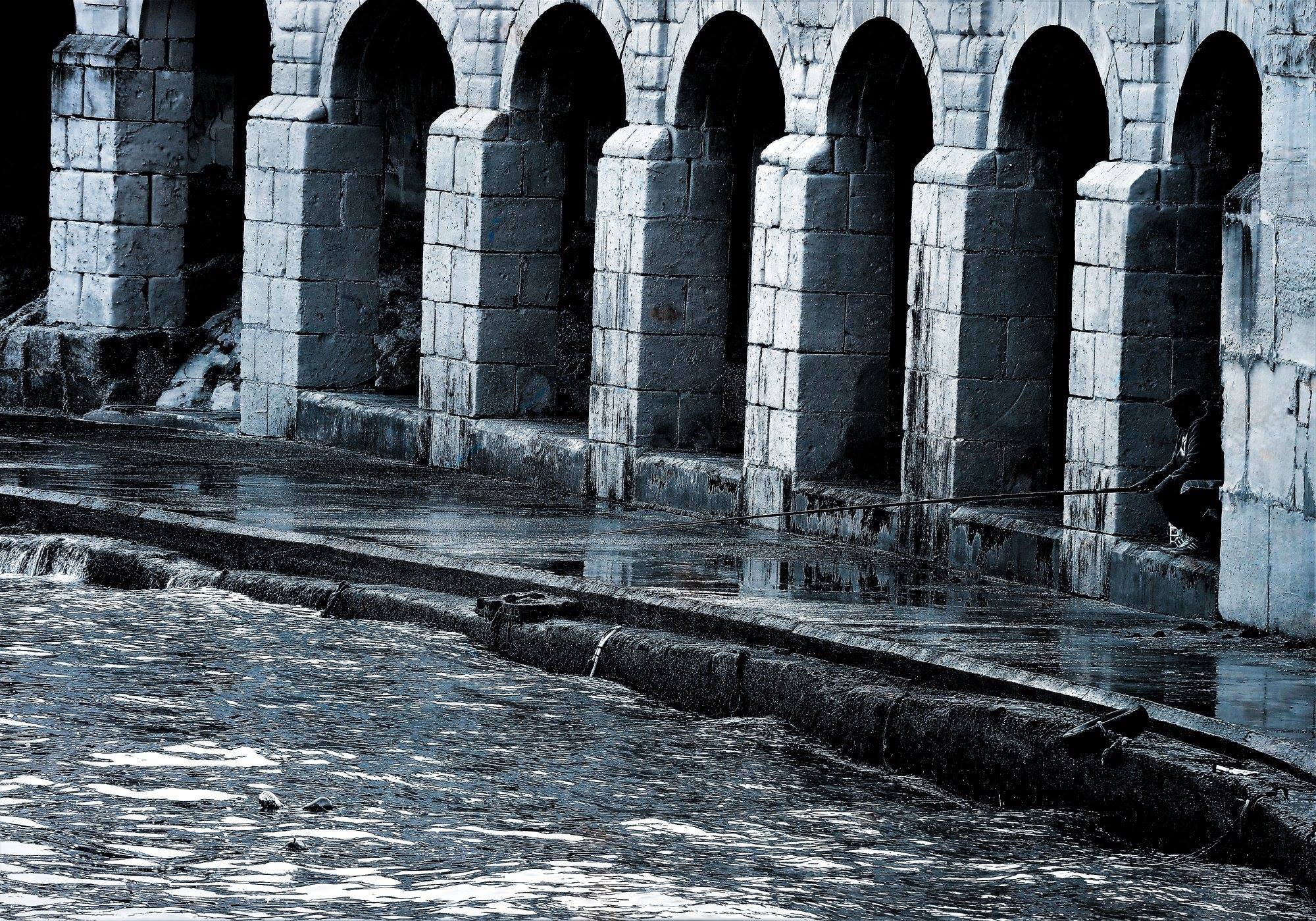 Arches and fisherman in Marsascala